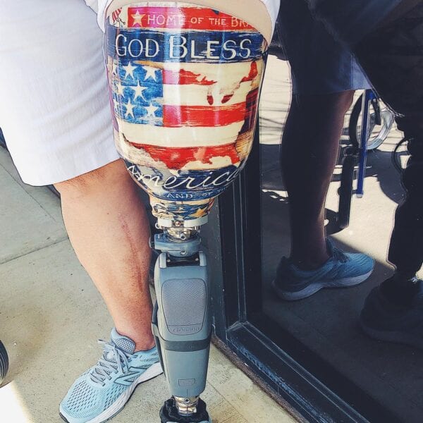 Female amputee with Above knee prosthetic leg custom socket with God Bless America and flag design