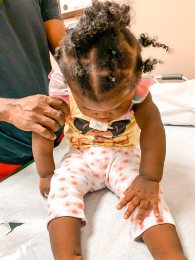 Baby girl with no neck control, head in downward position, unique orthotic case requires innovative solution to keep baby's head up