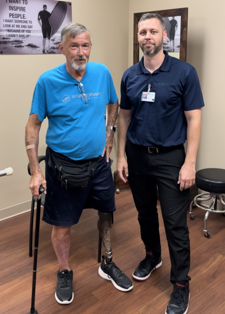 Patient with prosthetic leg standing with his prosthetist